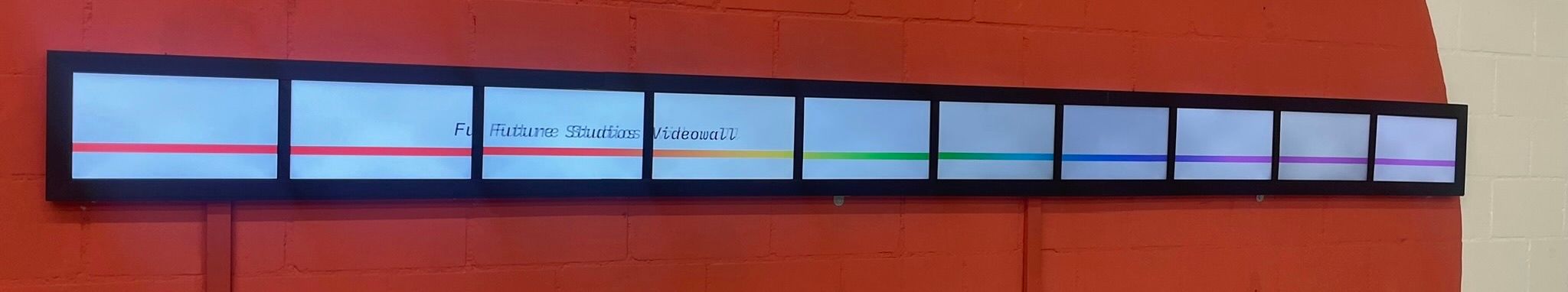 A cropped photo of the final video wall, 10 wall mounted laptop displays in sync